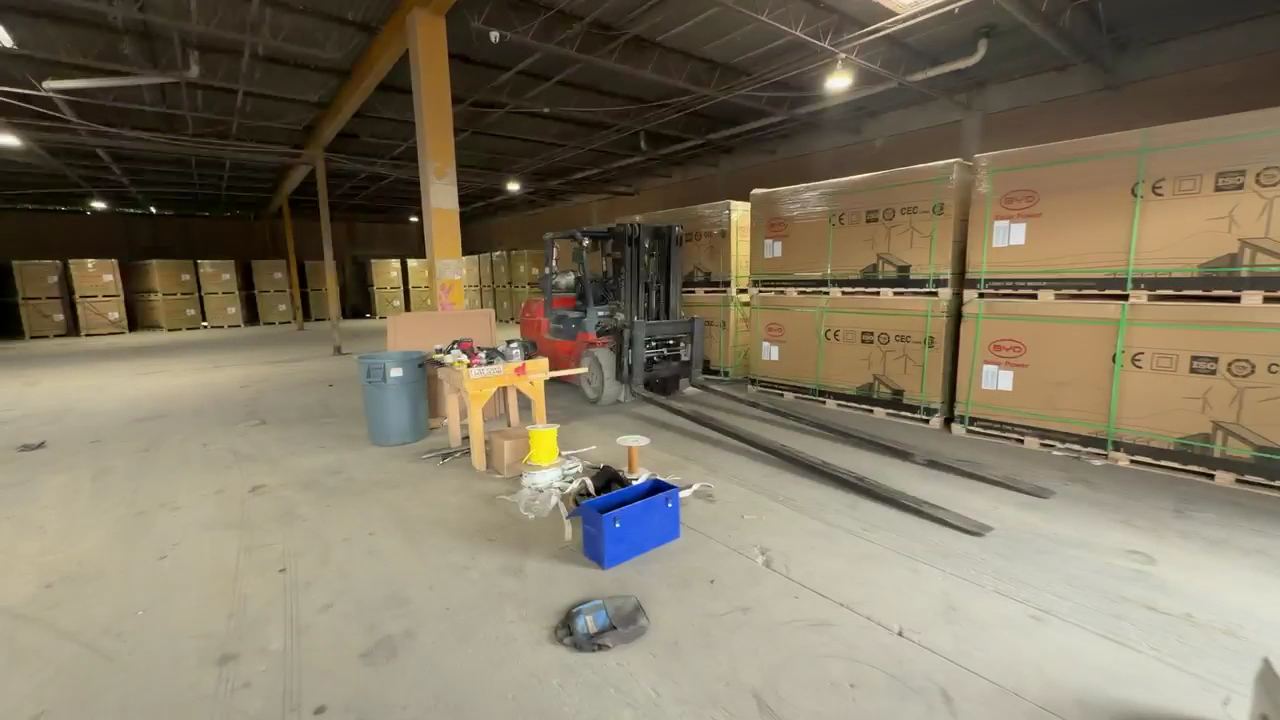 A forklift moving palletized cargo inside the Aeneas Exporting warehouse
